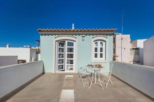 un patio con tavolo e sedie su un balcone di RG Casa do Carmo a Faro Altre 9 foto