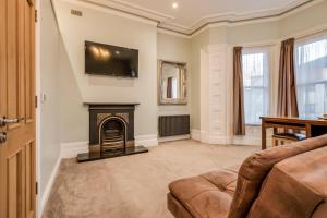 a living room with a fireplace and a tv on the wall at Central Belfast Apartments Harpers in Belfast
