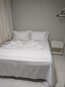 a white bed with white towels on top of it at Pousada Chapada do Araripe in Araripina