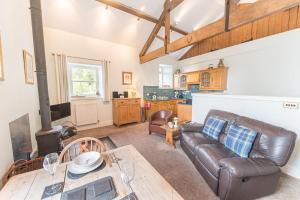 uma sala de estar com um sofá de couro e uma mesa em Stables Cottage Far Sawrey Windermere em Far Sawrey