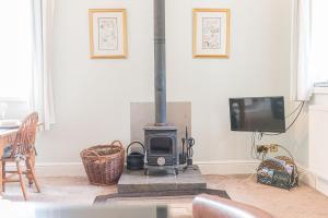 a living room with a wood stove and a tv at Stables Cottage Far Sawrey Windermere in Far Sawrey