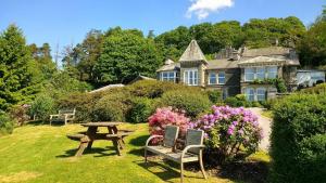 a picnic table in front of a house with flowers at Stables Cottage Far Sawrey Windermere in Far Sawrey