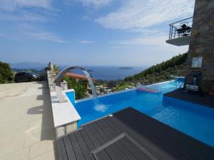 a large blue swimming pool with a water slide at Sky Sea Resort & Villas in Skiathos Town