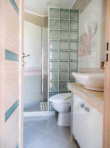 ein Bad mit einem WC, einem Waschbecken und einer Dusche in der Unterkunft Sky Sea Resort & Villas in Skiathos-Stadt