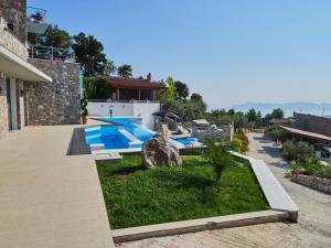 a backyard with a swimming pool and a house at Sky Sea Resort & Villas in Skiathos Town