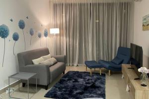 sala de estar con sofá y sillas azules en KL Gateway Premium Residence near to Mid Valley Bangsar, en Kuala Lumpur