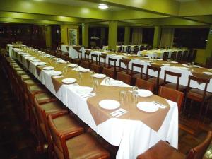 a long table in a restaurant with white tables and chairs at HOTEL SAN ANDRES *** in Trujillo