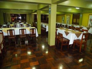 a dining room with white tables and wooden chairs at HOTEL SAN ANDRES *** in Trujillo