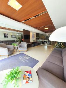 eine Bürolobby mit einem Sofa und einem Tisch in der Unterkunft Avenida Palace Hotel in Joinville