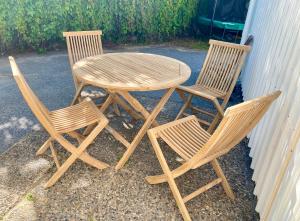 een houten tafel en twee stoelen naast een muur bij Helgas Hus tre rum o kök in Hunnebostrand