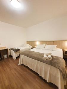 um quarto de hotel com duas camas com toalhas em Avenida Palace Hotel em Joinville