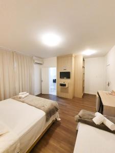 um quarto de hotel com duas camas e uma televisão em Avenida Palace Hotel em Joinville