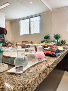 a counter with several different colored vases on it at Avenida Palace Hotel in Joinville