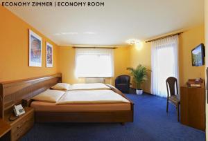 a bedroom with a bed in a room with yellow walls at Hotel Hanauerhof in Appenweier