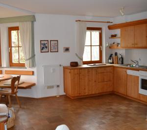 una cocina con armarios de madera y una mesa. en Ferienwohnung Am Anger, en Samerberg