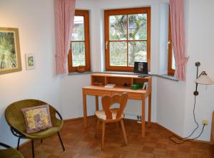 una oficina con escritorio y 2 sillas en Ferienwohnung Am Anger, en Samerberg