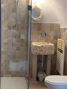 een badkamer met een douche, een wastafel en een toilet bij Trulli Antichi Mestieri - Widespread Trulli in the historic center in Alberobello