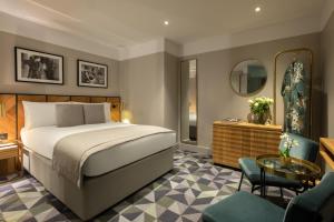 a bedroom with a bed and a table and chairs at Victory House Leicester Square in London