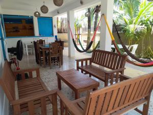 um restaurante com cadeiras e mesas de madeira e um baloiço em La Casa del Ritmo em El Cuyo