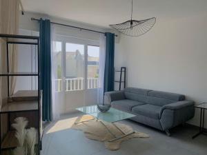 salon z kanapą i szklanym stołem w obiekcie T1 bis cosy et spacieux - wifi - parking gratuit w mieście Angers