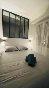 una mochila verde sentada en una cama en un dormitorio en T1 bis cosy et spacieux - wifi - parking gratuit en Angers