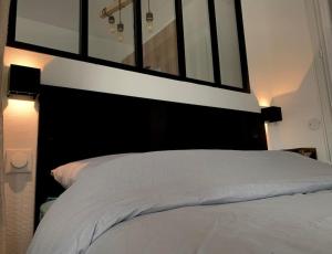 a bedroom with a large white bed with a black headboard at T1 bis cosy et spacieux - wifi - parking gratuit in Angers