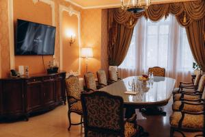 uma sala de jantar com uma mesa e cadeiras e uma televisão em Hotel Bristol em Odessa