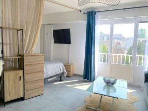 a living room with a bed and a glass table at T1 bis cosy et spacieux - wifi - parking gratuit in Angers