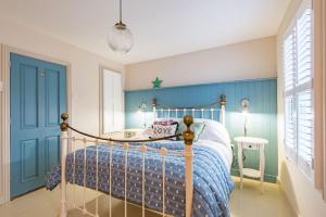 a bedroom with a bed and a blue wall at Star Cottage in Whitstable