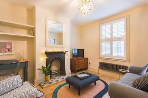 a living room with a fireplace and a tv at Star Cottage in Whitstable