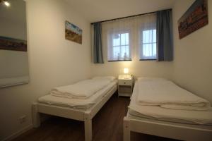 dwa łóżka w pokoju z oknem w obiekcie Haus-Frisia-Appartement-402 w mieście Sankt Peter-Ording