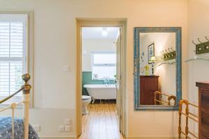 a bathroom with a tub and a sink and a mirror at Star Cottage in Whitstable +39 photos