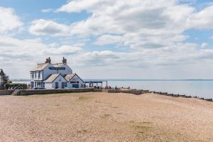 a building on the beach next to the water at Star Cottage in Whitstable
