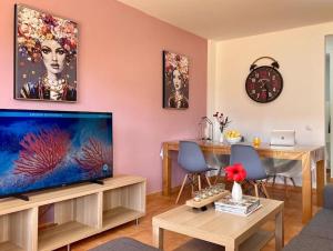un soggiorno con una grande TV a schermo piatto di Precioso apto 4 pers, 2 piscinas, fibra óptica a Corralejo