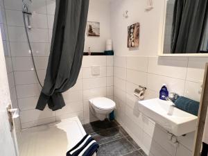 een badkamer met een toilet en een wastafel bij Ferienwohnung Elfriede - 2 Bäder, Küche, großes Wohnzimmer, Freisitz, 2 Parkplätze, im Ortskern in Malterdingen