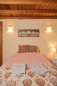 a bedroom with a bed with two towels on it at Nómada in San Martín de los Andes