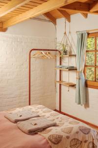 聖馬丁德洛斯安第斯的住宿－Nómada，一间卧室设有一张床、一个架子和一个窗户