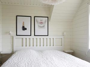 ein weißes Schlafzimmer mit 3 Bildern über einem Bett in der Unterkunft Holiday home KUNGSHAMN III in Kungshamn