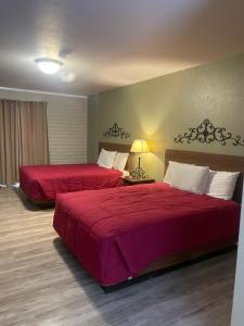 2 posti letto in camera d'albergo con lenzuola rosse di Roosevelt Resort Park a Roosevelt