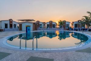 a swimming pool in front of some houses at Flamingo Club and Resort Una 3 Km Away from Diu Check Post in Diu