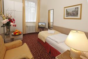 pokój hotelowy z łóżkiem i stołem w obiekcie Romania w Karlowych Warach