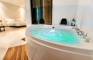 a bath tub in a bathroom with a sink at CasaGuana in Playa Hermosa