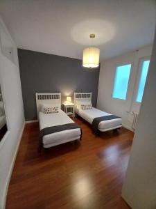 a room with two beds in a room with wood floors at Live Like A Local In Bcn in Barcelona