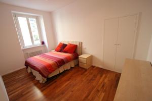 a bedroom with a bed with two red pillows on it at Cernobbio 2 Bedroom Apartment in Cernobbio