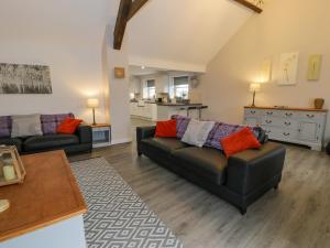 een woonkamer met twee banken en een keuken bij Bodrual Cottage in Caernarfon