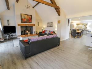 een woonkamer met een bank en een tv bij Bodrual Cottage in Caernarfon