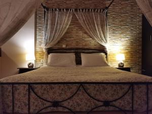 um quarto com uma cama grande e uma parede de tijolos em Ataviros Hotel em Émbonas