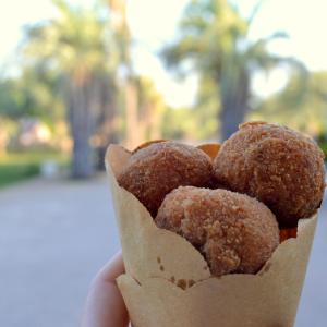a hand holding a handful of sugar covered donuts at Cambiocavallo Resort in Zimmardo