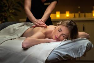 una mujer recibiendo un masaje en una cama en The Abbey Resort en Lake Geneva