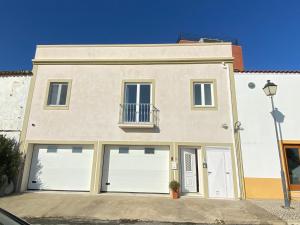 a large white house with two garage doors at The Little Owls Nest Castro Verde in Castro Verde